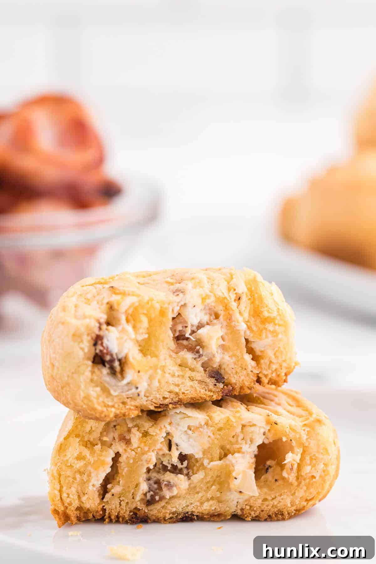 A stack of golden, delicious Cheesy Bacon Pinwheels on a wire rack, ready for serving or cooling, with melted cheese and visible bacon bits.