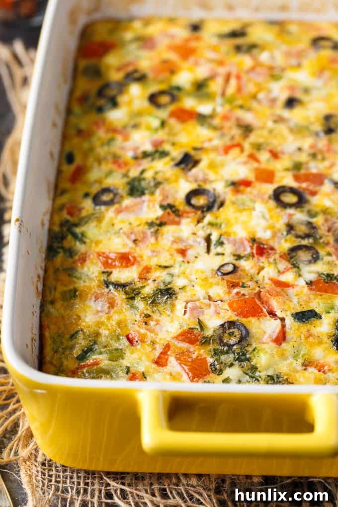 Mediterranean Sunrise Bake 3 Close-up of Mediterranean Brunch Bake ingredients before baking, showing diced vegetables, feta cheese, and black olives in an egg mixture.