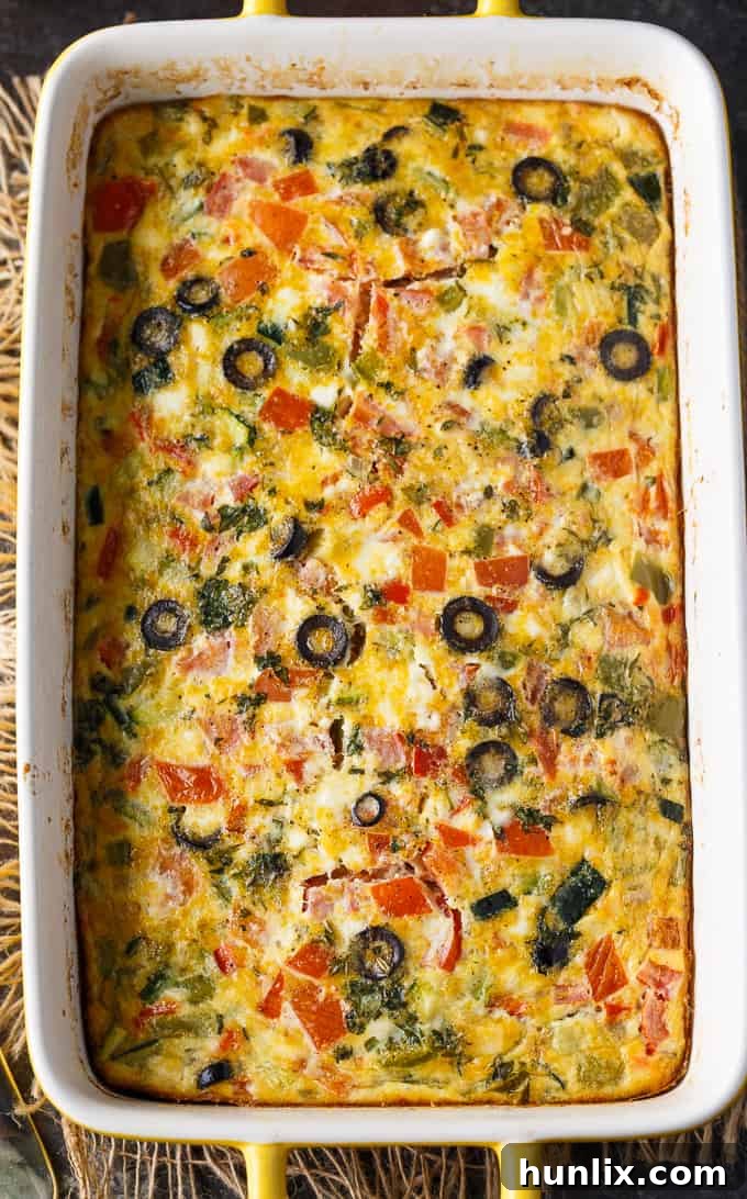 Mediterranean Sunrise Bake 4 A baked Mediterranean Brunch Bake, golden brown and bubbling, garnished with fresh herbs, ready to be served.