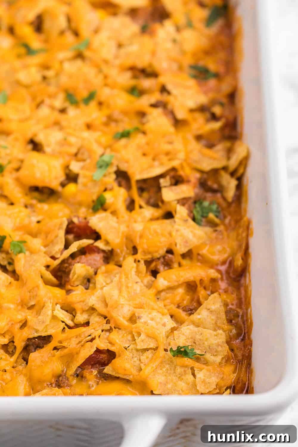 Fiesta Beef Nacho Bake 2 Beef nacho bake in a white casserole dish, perfectly golden brown and cheesy.