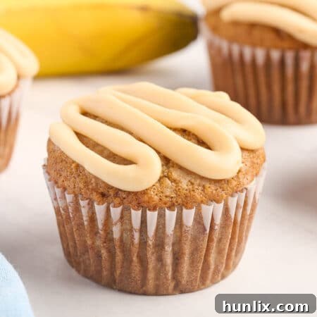 A caramel banana muffin on a white surface, showcasing its delicious topping and tender texture.