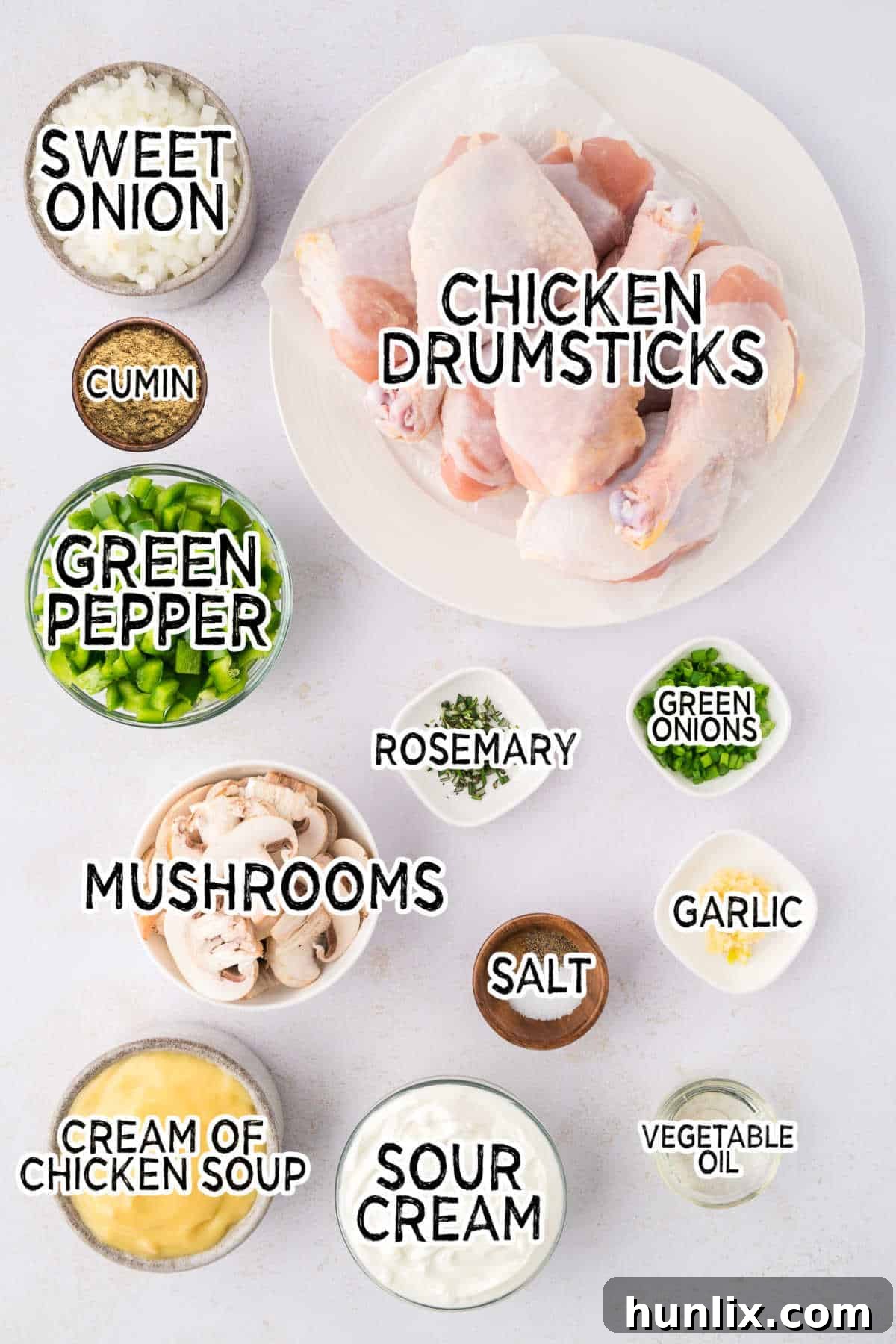 Tender Chicken in Rich Gravy 3 A vibrant flat lay image showcasing all the fresh ingredients needed to make smothered chicken, including chicken drumsticks, bell pepper, mushrooms, onions, herbs, and cans of soup.