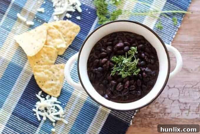 Slow Cooker Black Beans - Make the best dried black beans in the Crockpot! This bean recipe requires no soaking and simmers all day while you're at work for the easiest Taco Tuesday side dish.