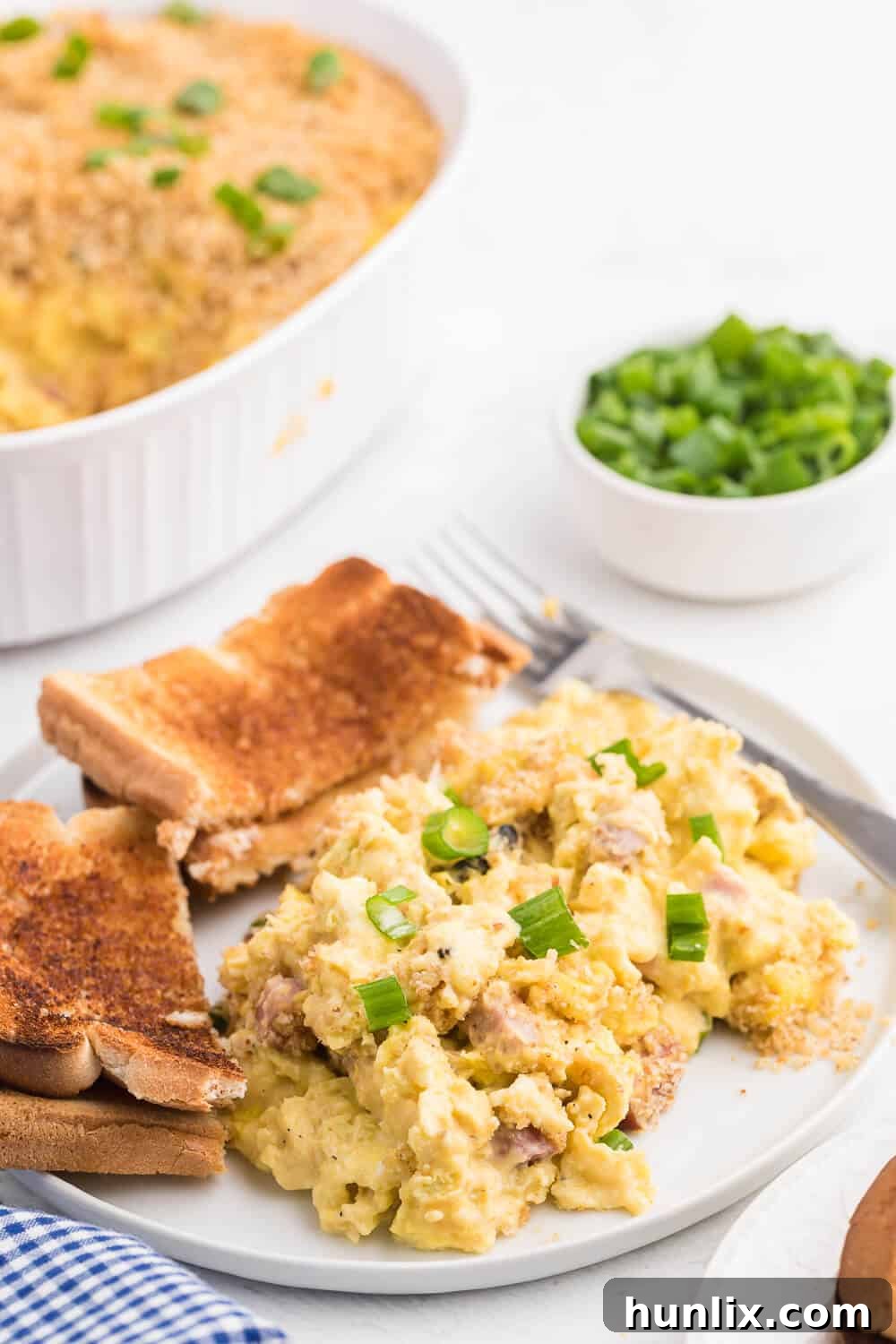 Sunrise Scramble Bake 5 A plated serving of the scrambled egg casserole, garnished with fresh green onions.