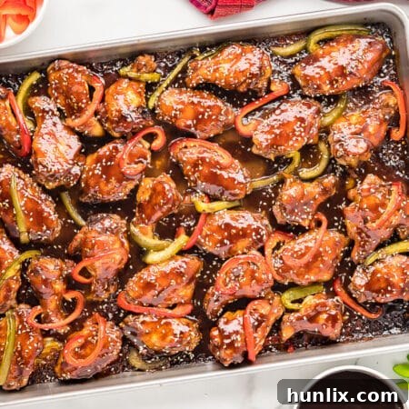 Baked Asian chicken wings on a baking sheet, glistening with sauce and ready to be served.