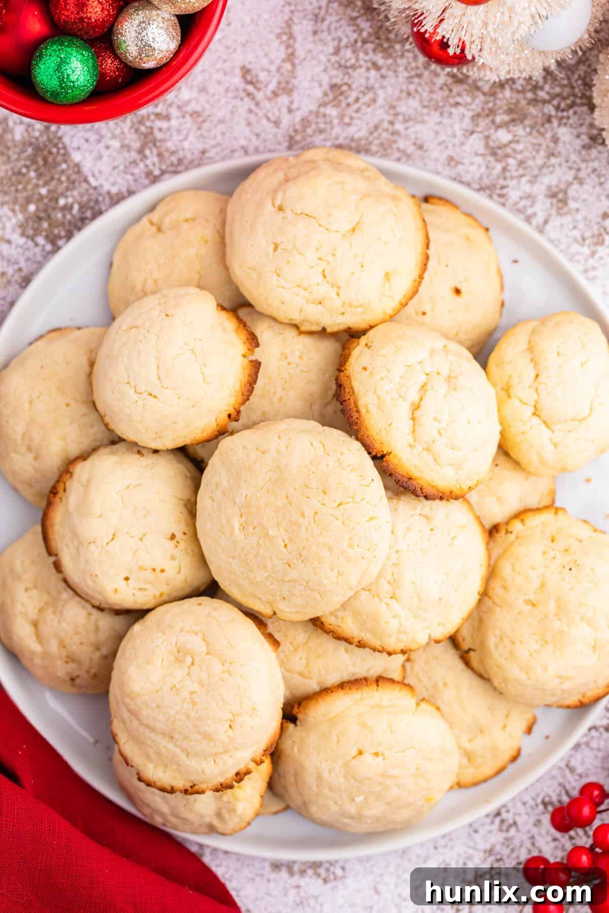 A plate piled high with golden-brown cream cheese cookies, inviting and delicious.