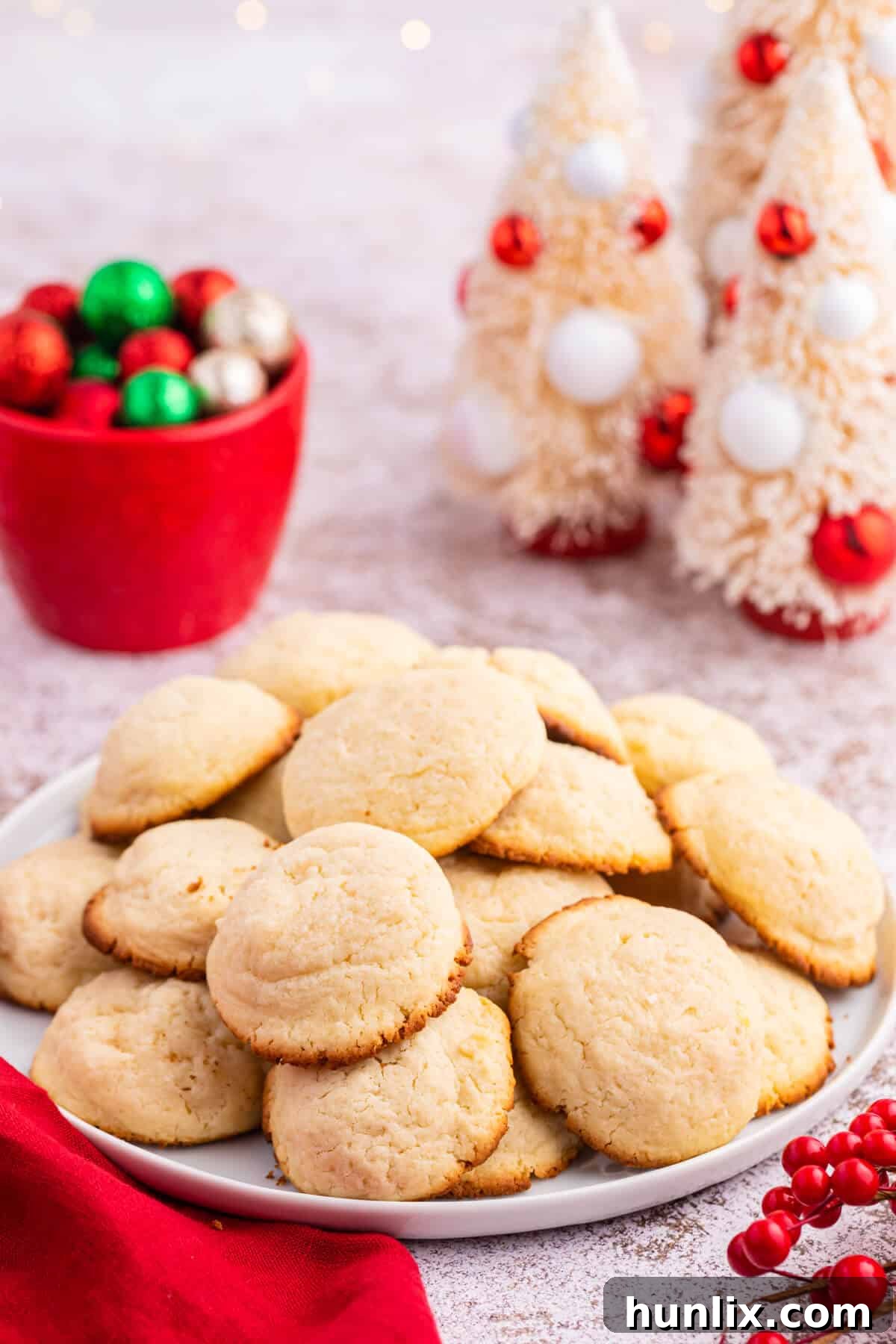 Cream cheese cookies artfully arranged on a round white plate.