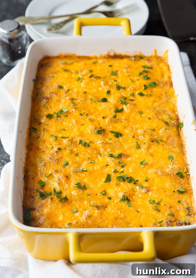 A close-up of a slice of Bacon, Spinach & Mushroom Crustless Quiche, showing the layers of cheese, eggs, and cooked vegetables. This hearty and healthy breakfast is perfect for meal prep or feeding a crowd, emphasizing its low-carb and flavor-rich qualities.