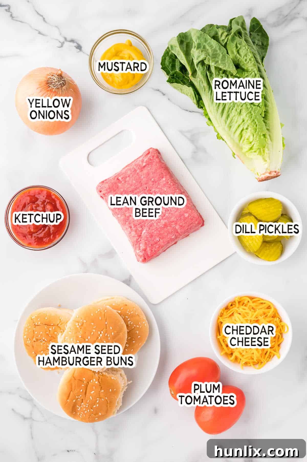 Cheeseburger in a Bowl 3 A collection of fresh ingredients laid out, including ground beef, lettuce, tomatoes, pickles, cheese, and bun tops, ready to be assembled into a cheeseburger salad.