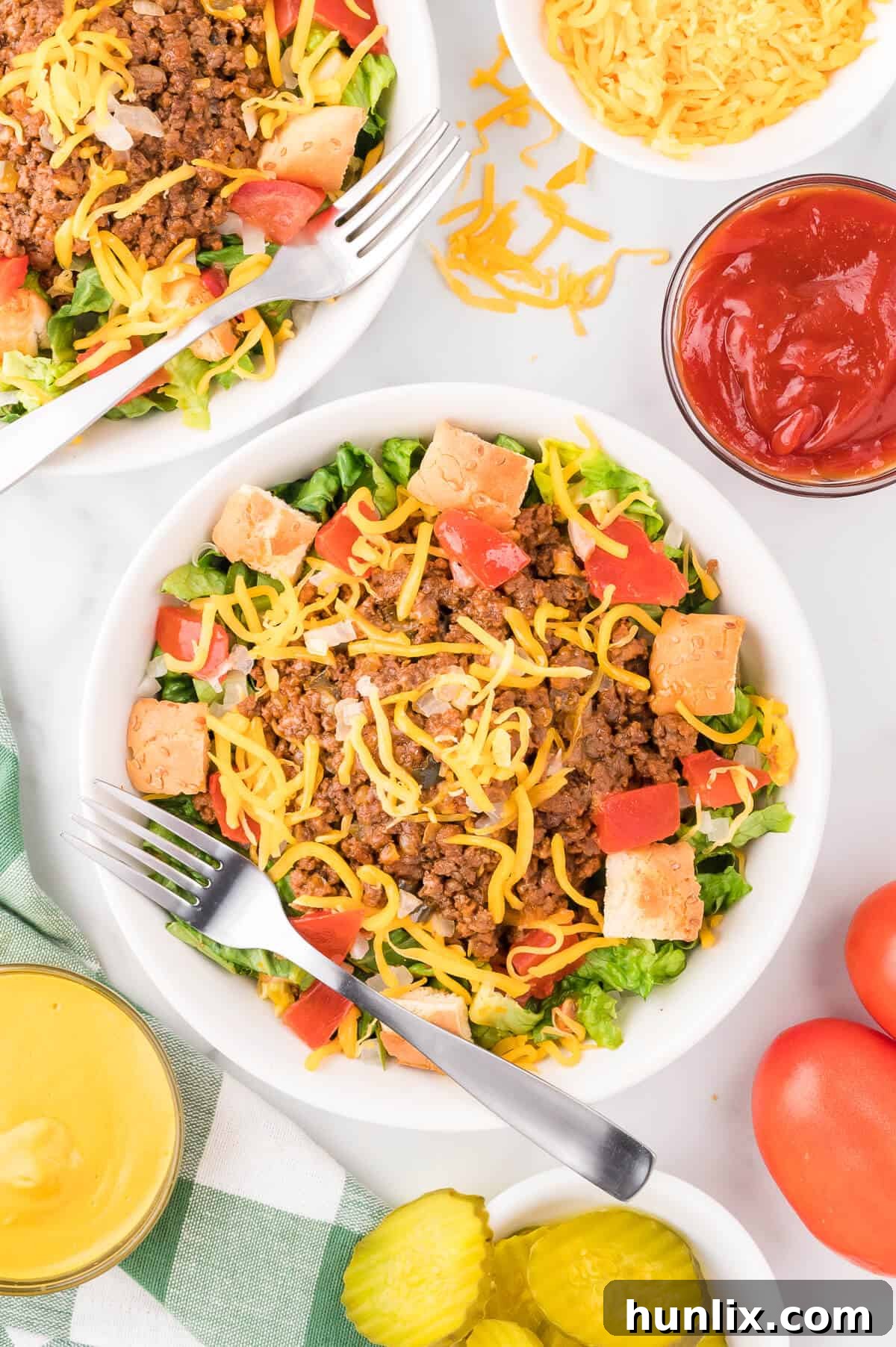 Cheeseburger in a Bowl 9 A beautifully arranged bowl of cheeseburger salad, surrounded by its fresh ingredients, emphasizing its wholesome appeal.