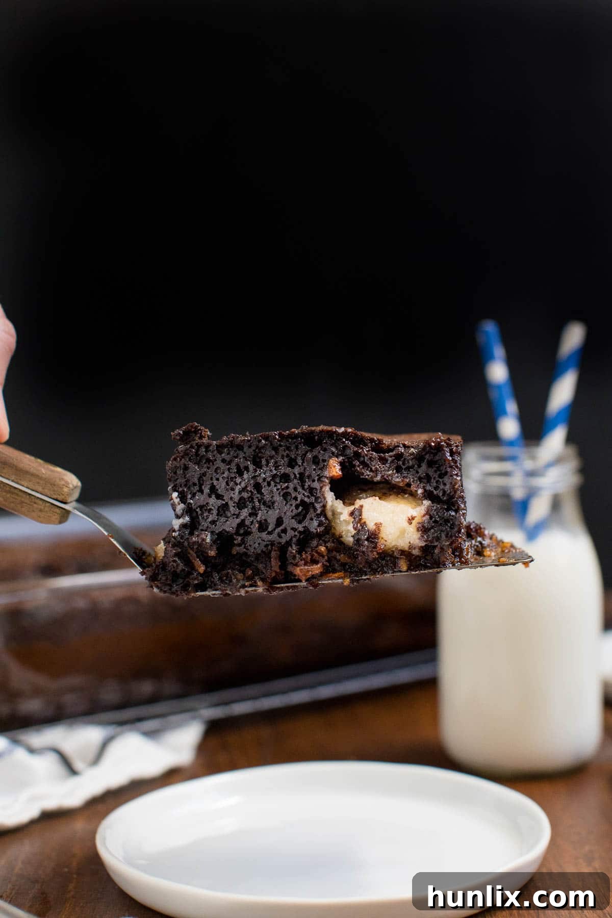 A slice of earthquake cake on a spatula, showing the layers.