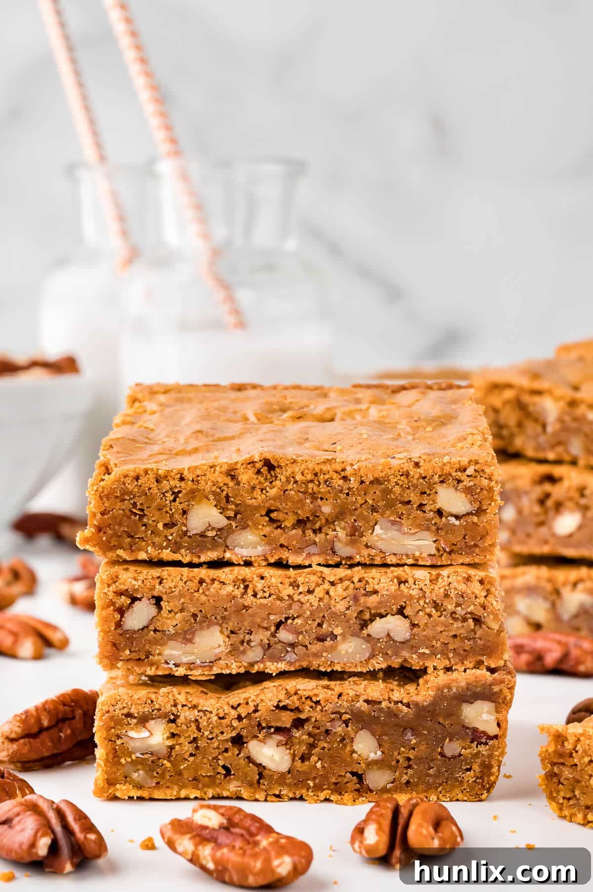 A stack of golden brown Penuche squares on a plate, showcasing their inviting texture.