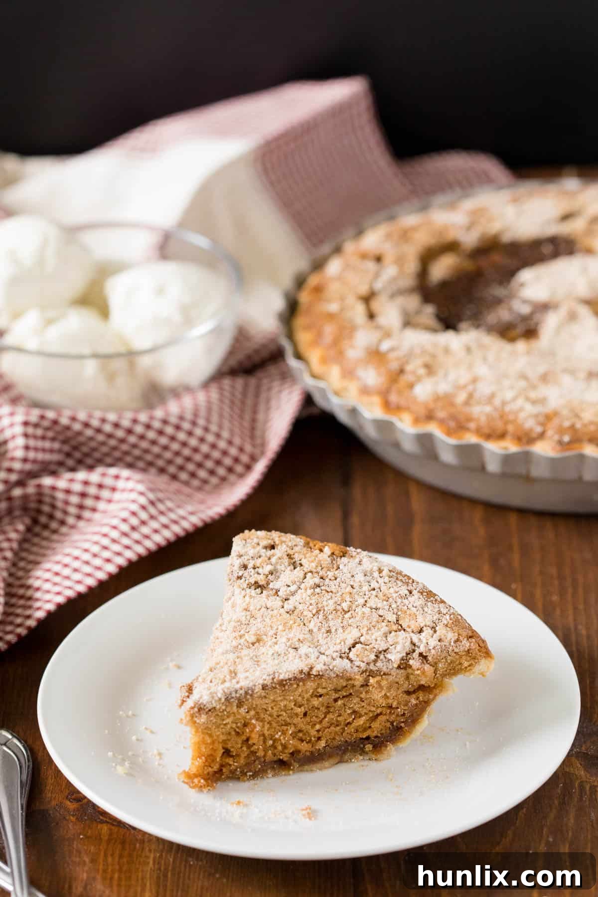 A delicious slice of Shoofly Pie, a traditional Pennsylvania Dutch dessert, served on a white plate with a fork.