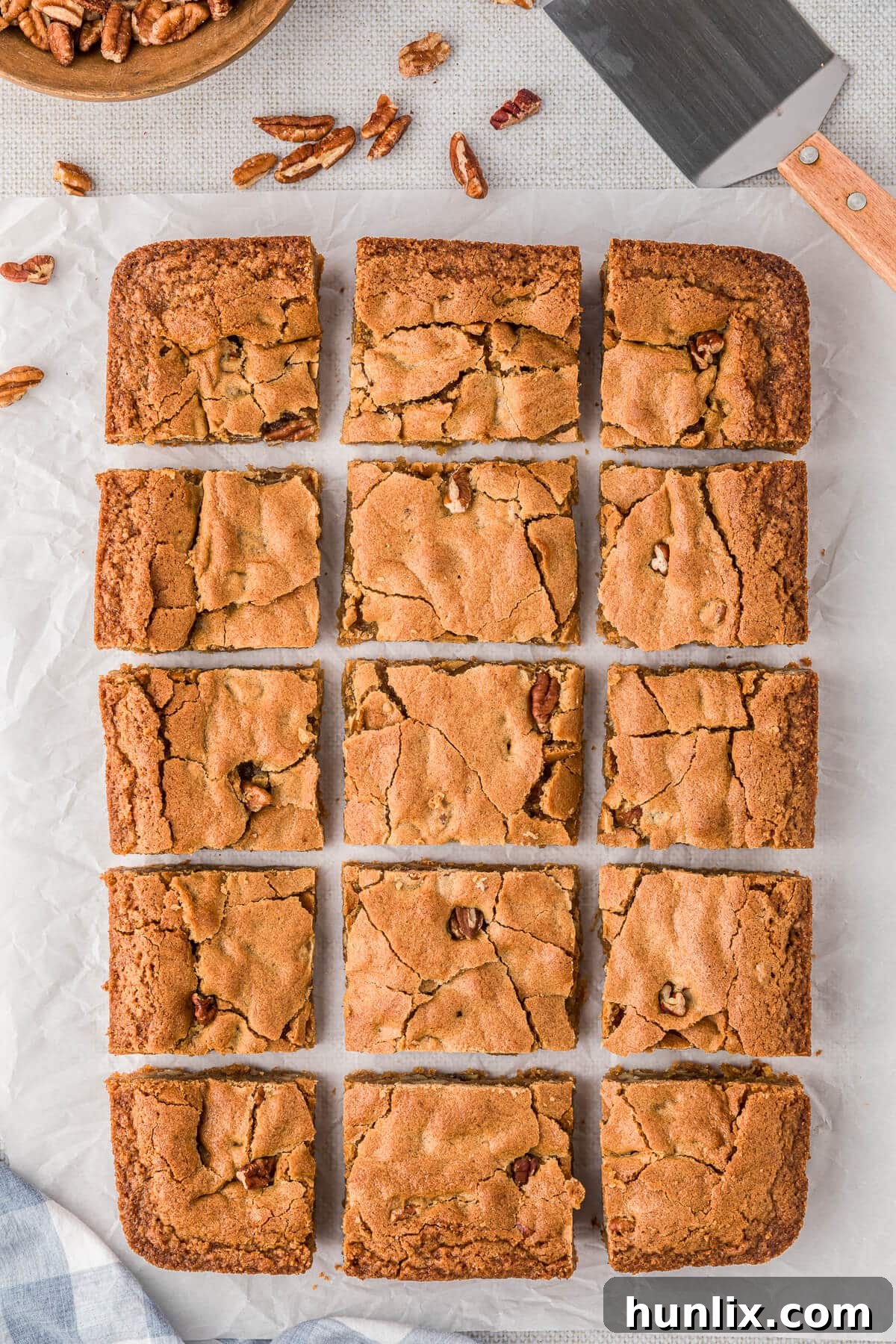 Perfectly cut butterscotch blondies on a piece of parchment paper, showcasing their golden-brown edges and soft centers.