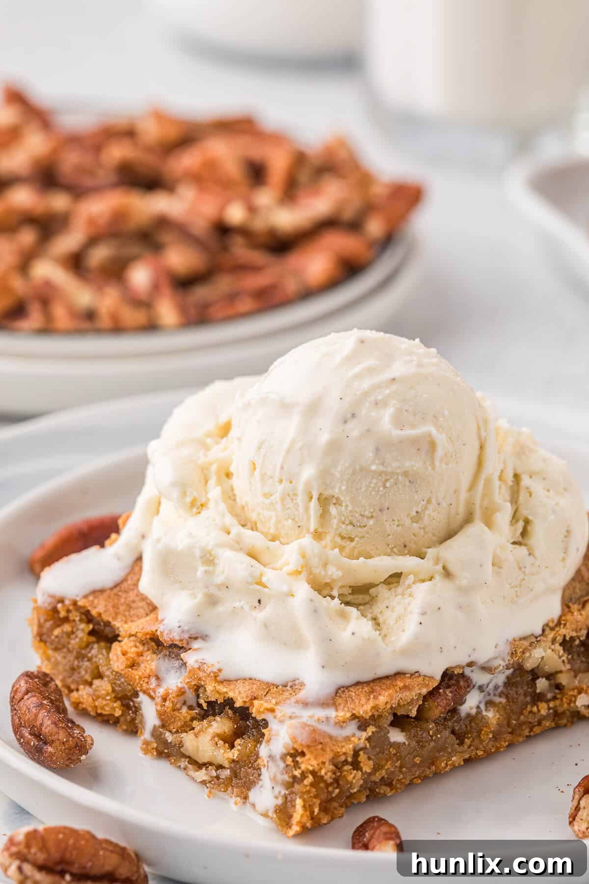 A serving of butterscotch blondie topped with a generous scoop of vanilla ice cream, ready to be enjoyed.