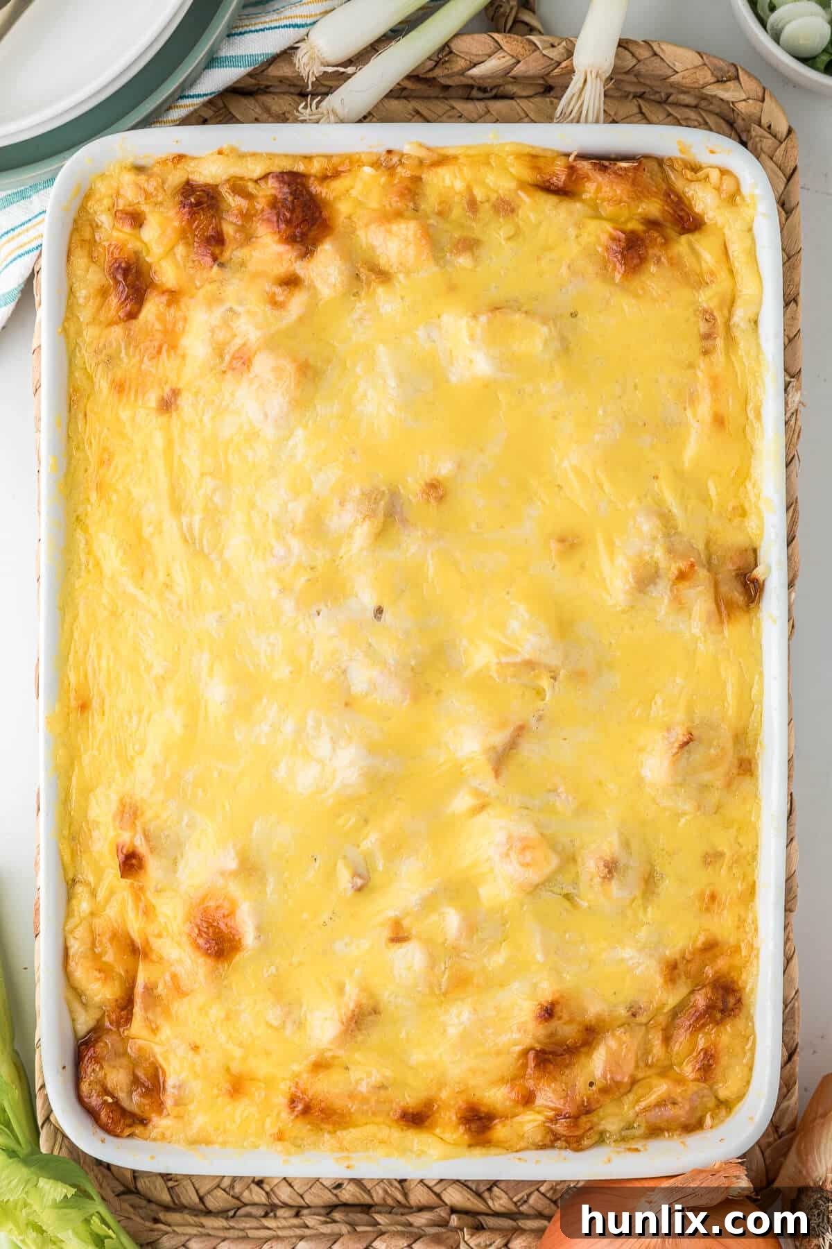 A golden-brown Chicken Cordon Bleu Casserole in a baking dish, fresh from the oven, with steam gently rising.