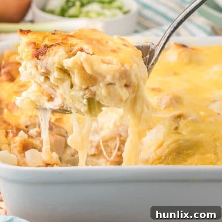 A serving spoon with chicken cordon bleu casserole on it.