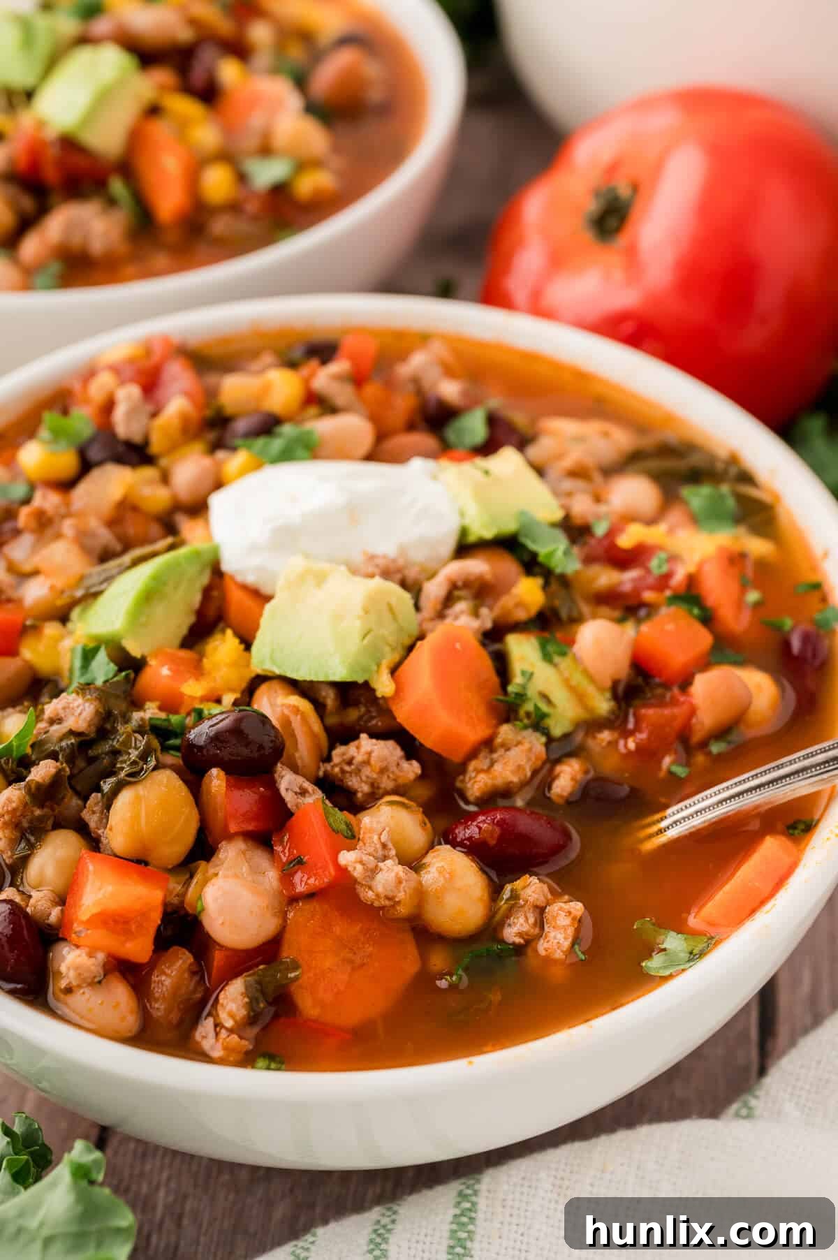 A perfectly garnished bowl of southwestern turkey 5 bean chili.