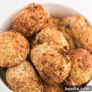 Close-up of crispy air fryer mozzarella balls in a white bowl.