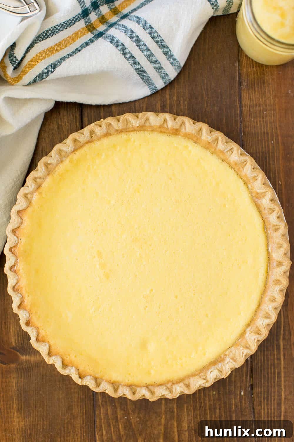 A beautifully baked Pineapple Pie on a rustic wooden board, ready to be sliced and served.