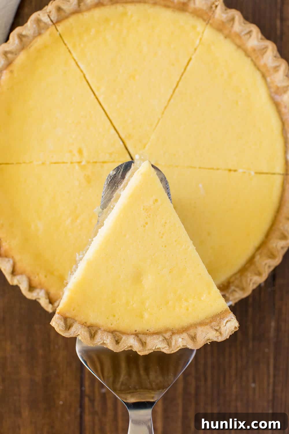 A beautiful slice of Pineapple Pie being lifted from the pie dish with a pie server, showcasing its creamy layers.