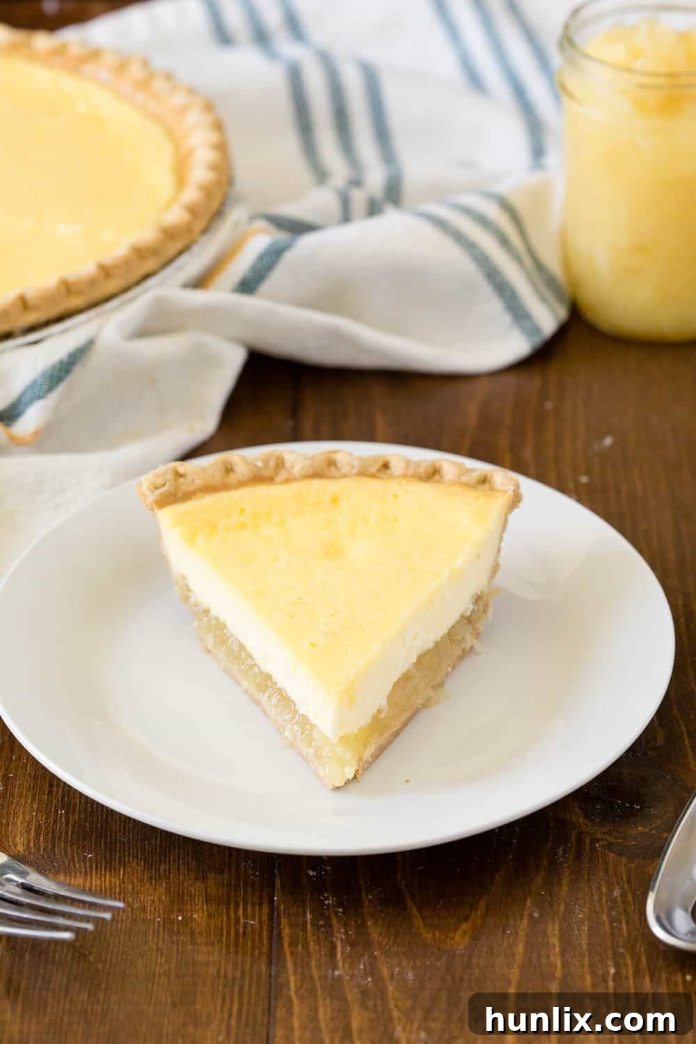 A perfectly portioned slice of Pineapple Pie on a white plate, showcasing the distinct layers of creamy filling and pineapple.