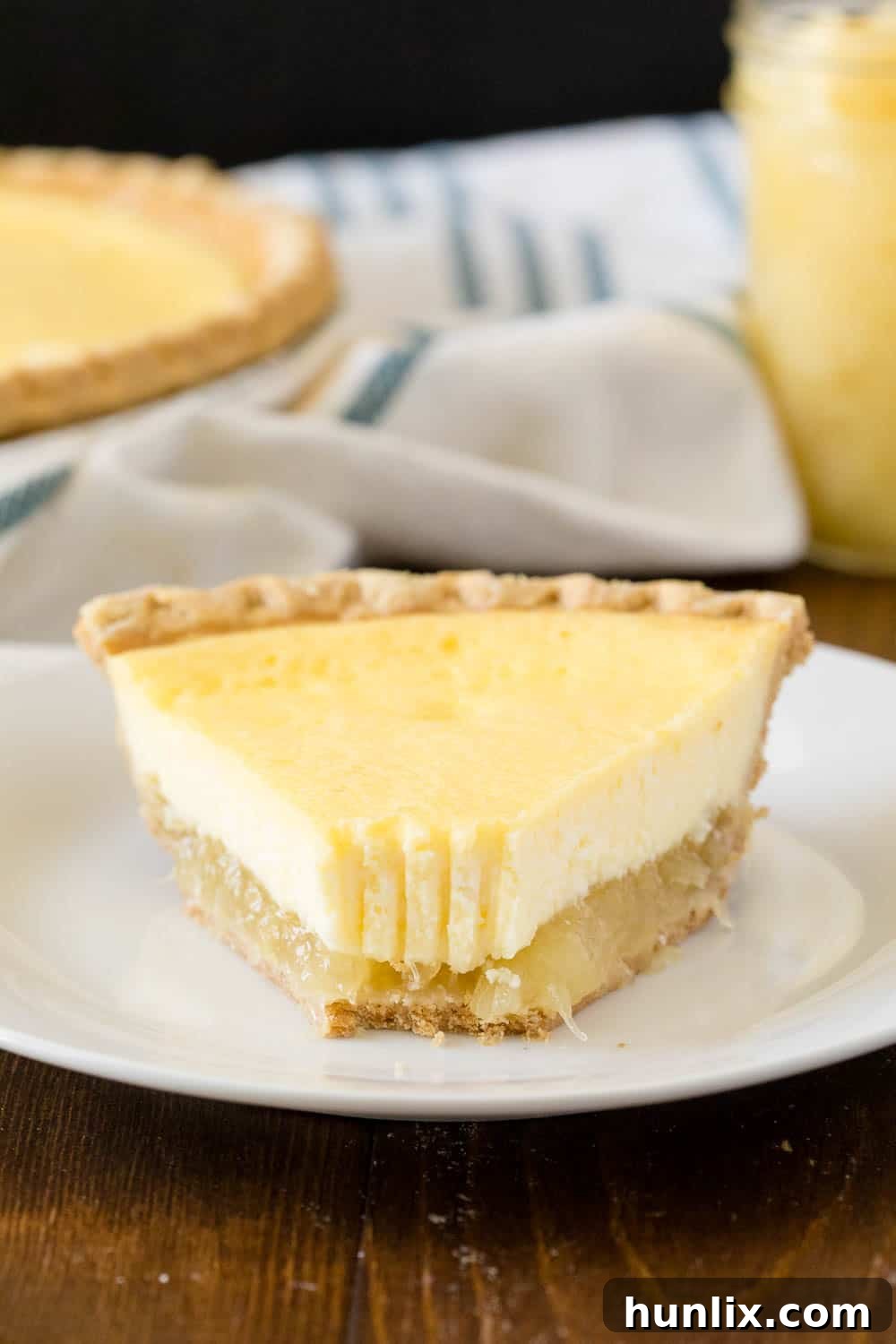 A tempting slice of Pineapple Pie on a white plate, with a small bite taken, indicating its irresistible appeal.