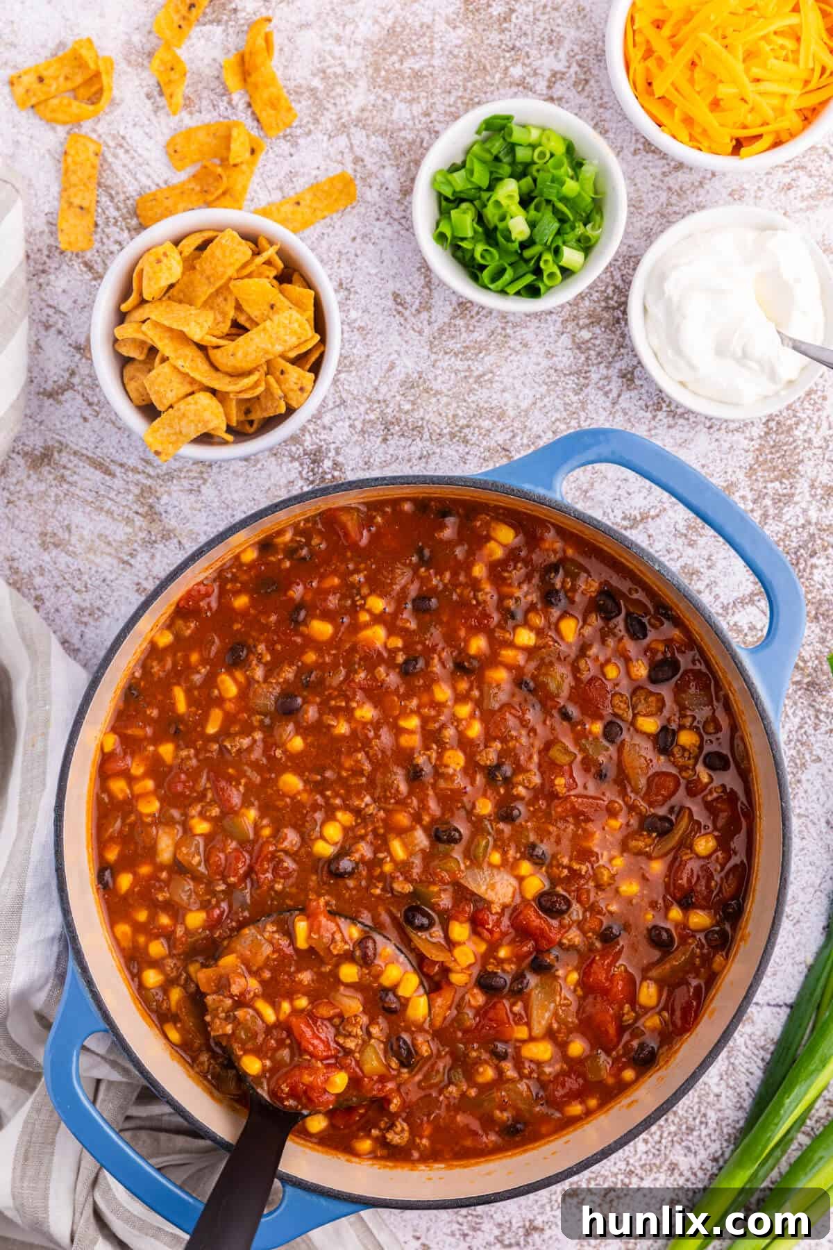 Taco chili in a dutch oven with a black ladle, ready to serve.