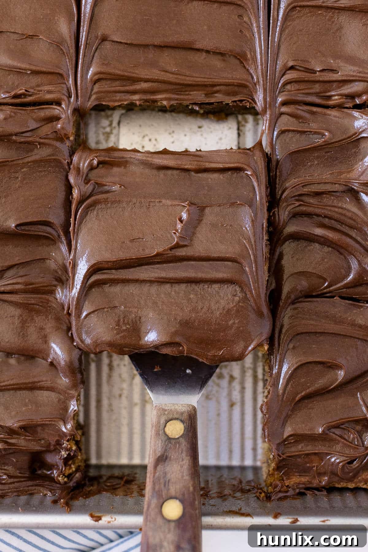 A slice of mocha cake on a spatula in a pan.