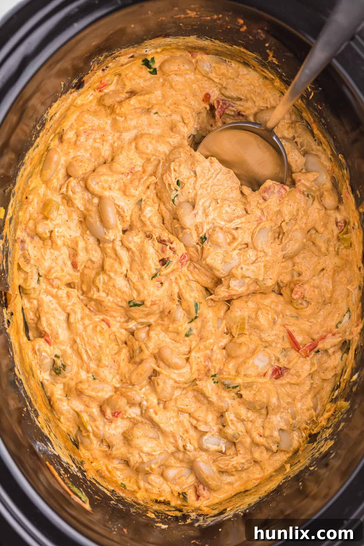 Creamy Crockpot White Chili Chicken Dip, a savory appetizer packed with chicken, cheese, and beans.