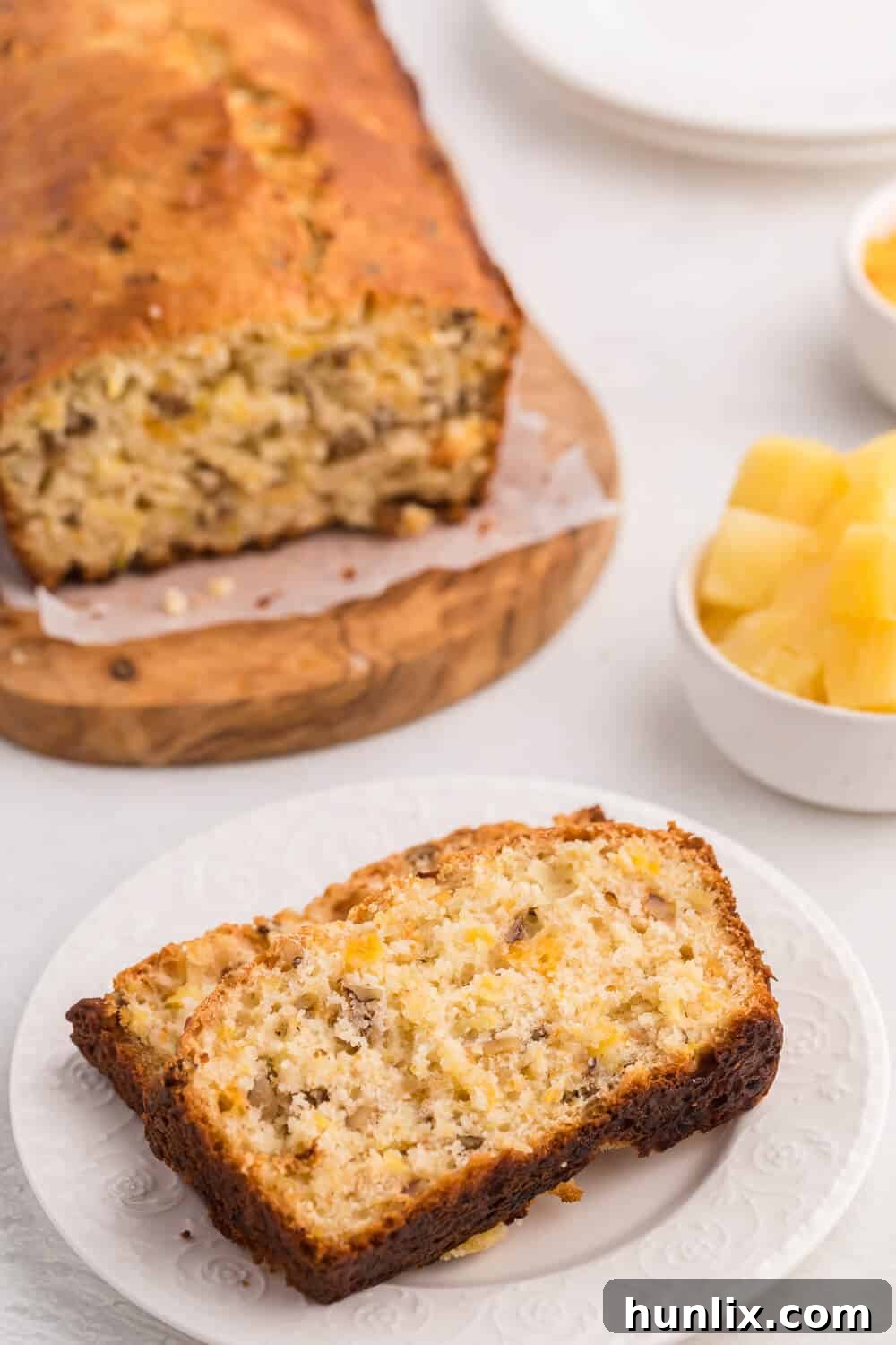 A cutting board with slices of Pineapple Cheese Bread and a knife