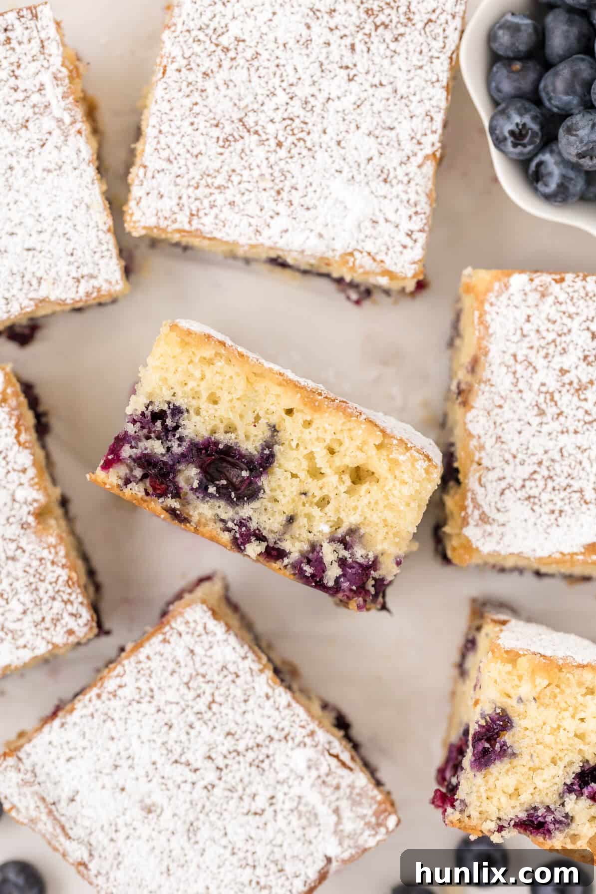A beautifully sliced Blueberry Tea Cake, showcasing its tender crumb and juicy berries, ready to be enjoyed.