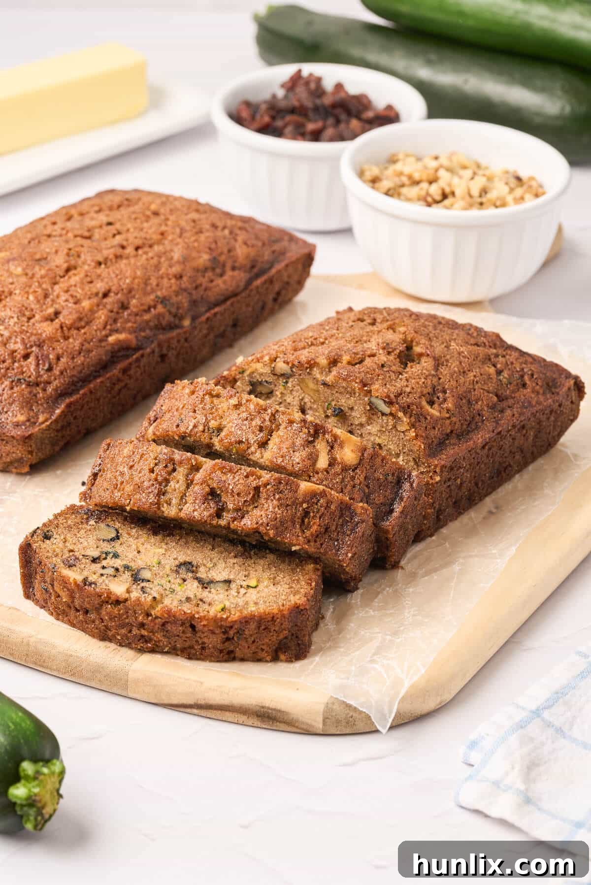 A loaf of zucchini bread on a cutting board with several slices already cut, ready to be served.