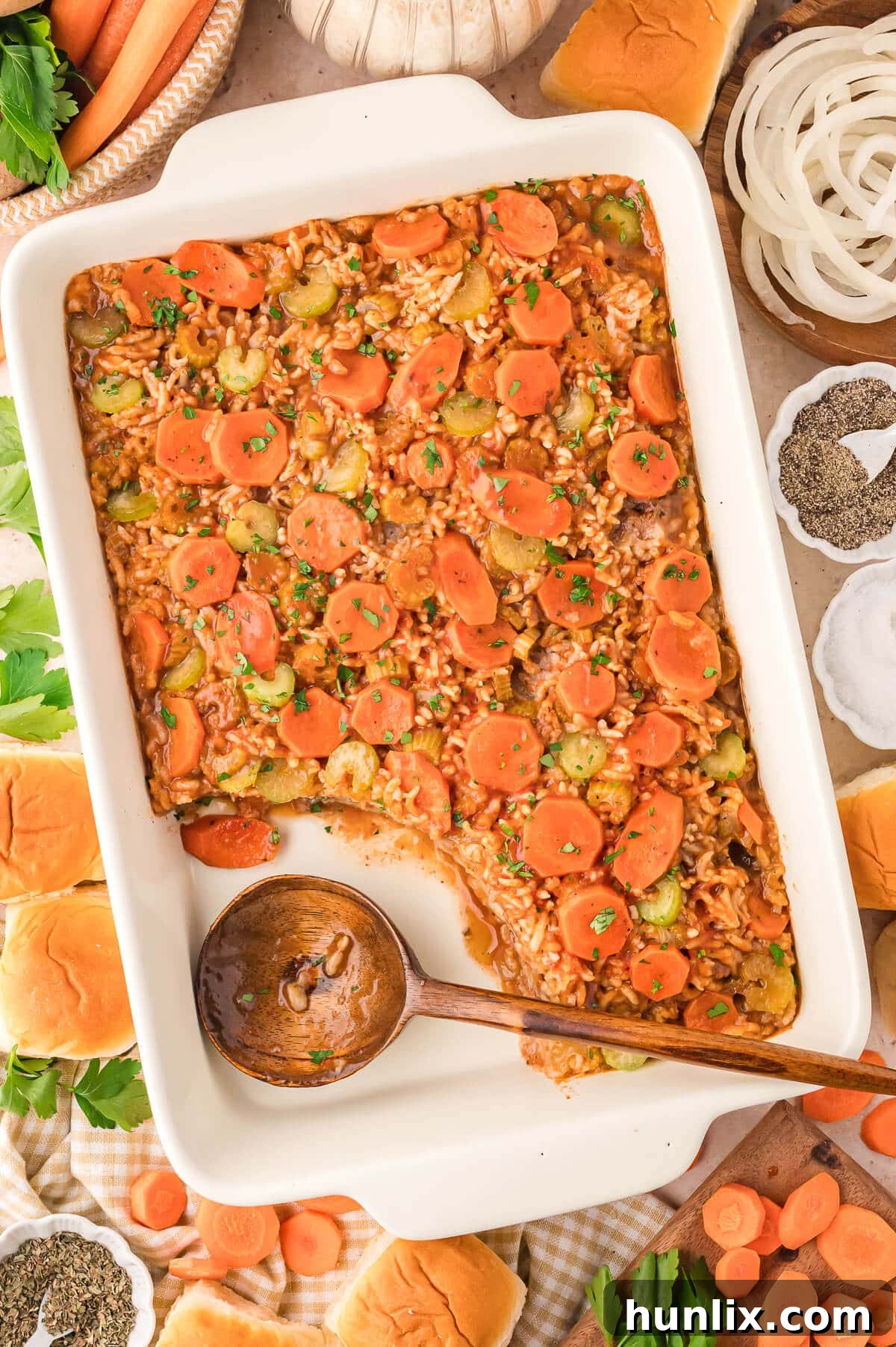 Castaway's Feast 6 The Shipwreck Casserole served in a pan with a wooden spoon inserted, showing off its layered goodness.