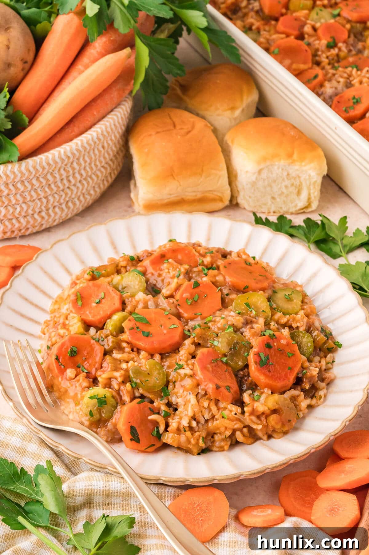 Castaway's Feast 7 A serving of Shipwreck Casserole on a white plate, showcasing the layered ingredients, with a wooden spoon in the background.