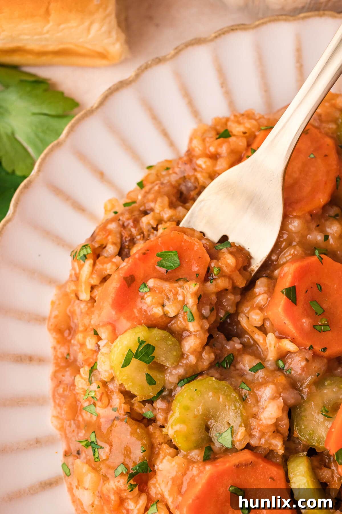 Castaway's Feast 8 A close-up of a serving of Shipwreck Casserole on a plate with a fork, highlighting the tender layers.