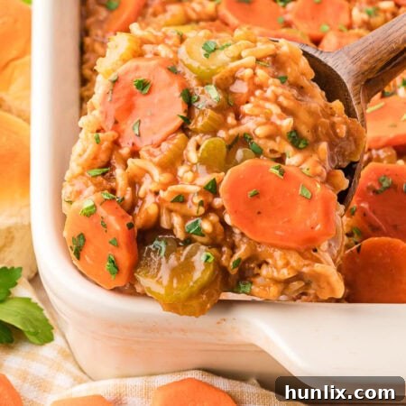 Castaway's Feast 9 The recipe in a pan and a wooden spoon serving a scoop of it.