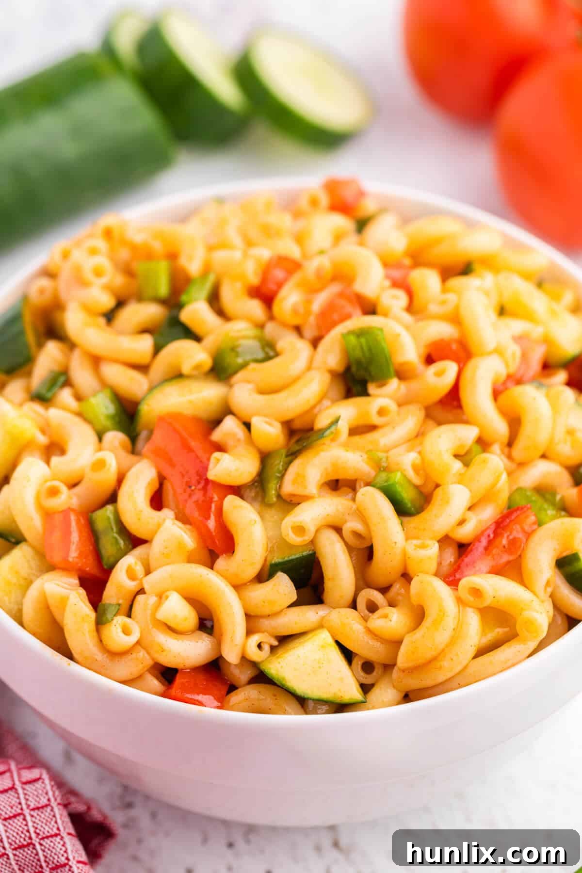 Creamy Pasta Delight 4 A large serving spoon scooping out a portion of the Macaroni Salad, highlighting the vibrant ingredients and inviting texture.