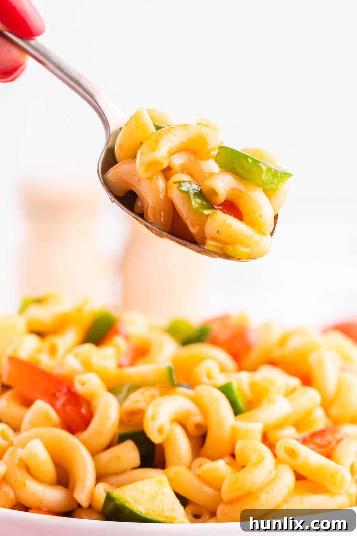 Creamy Pasta Delight 6 A close-up shot of Macaroni Salad on a spoon, ready to be tasted and enjoyed.