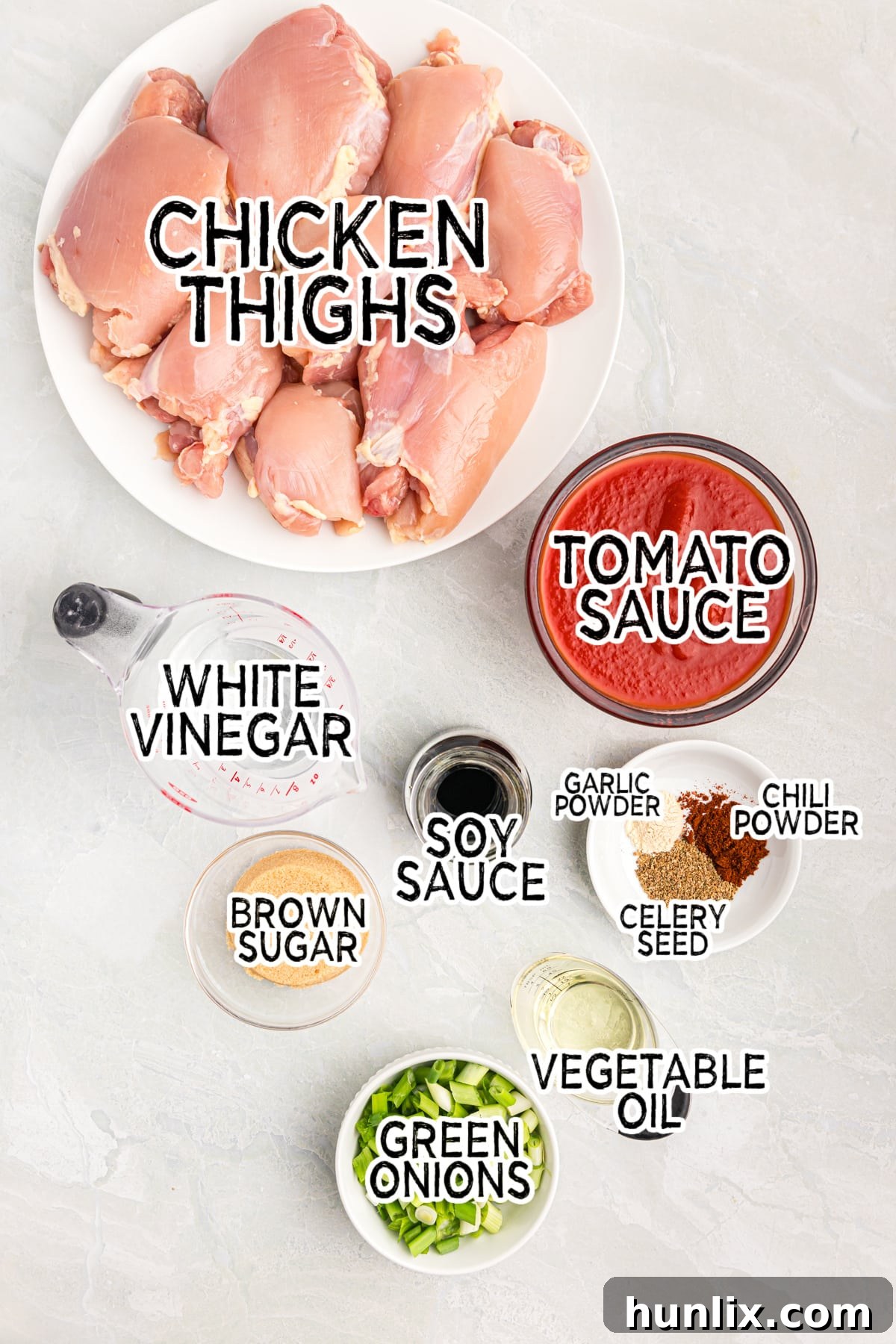 All the fresh ingredients laid out for making sweet and sour chicken, including chicken thighs, soy sauce, vegetables, and spices.