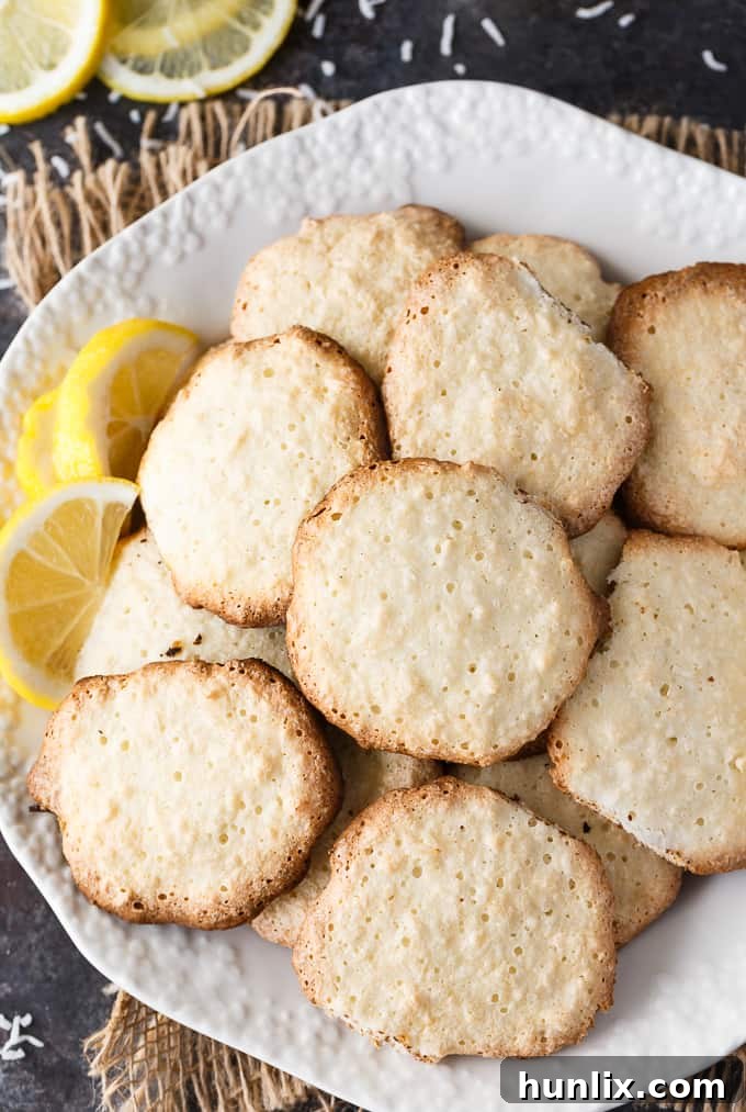 Sunshine Lemon Coconut Macaroons 5 Hand reaching for a Lemon Coconut Macaroon Cookie from a plate.
