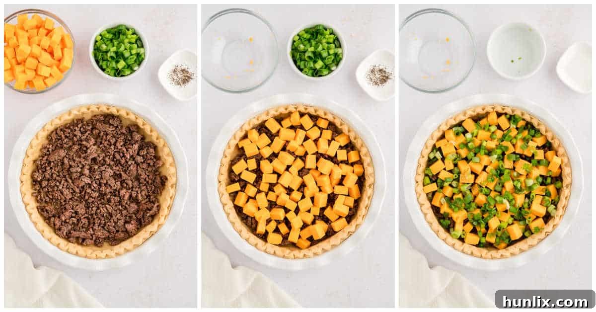 Ground beef, cheddar cheese, and green onions layered neatly in an unbaked pie shell.