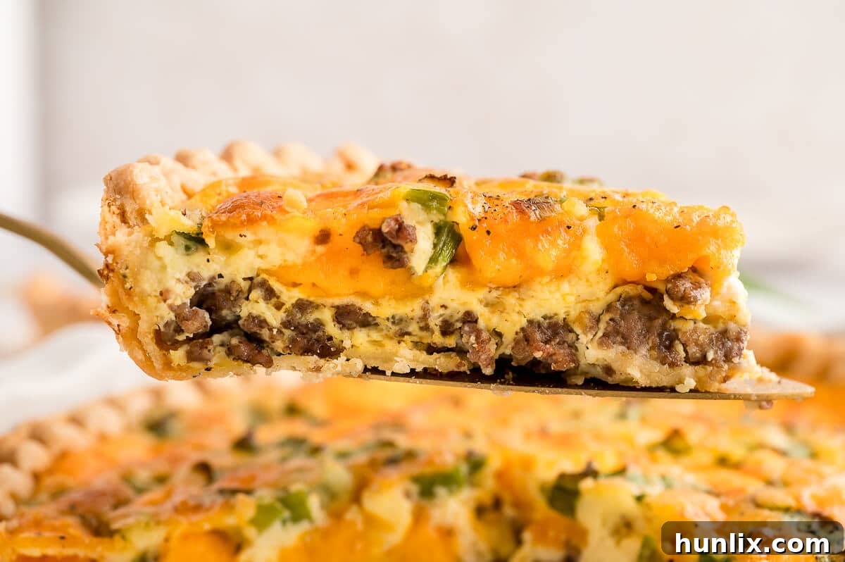 A close-up of a perfect slice of hamburger quiche resting on a pie server.