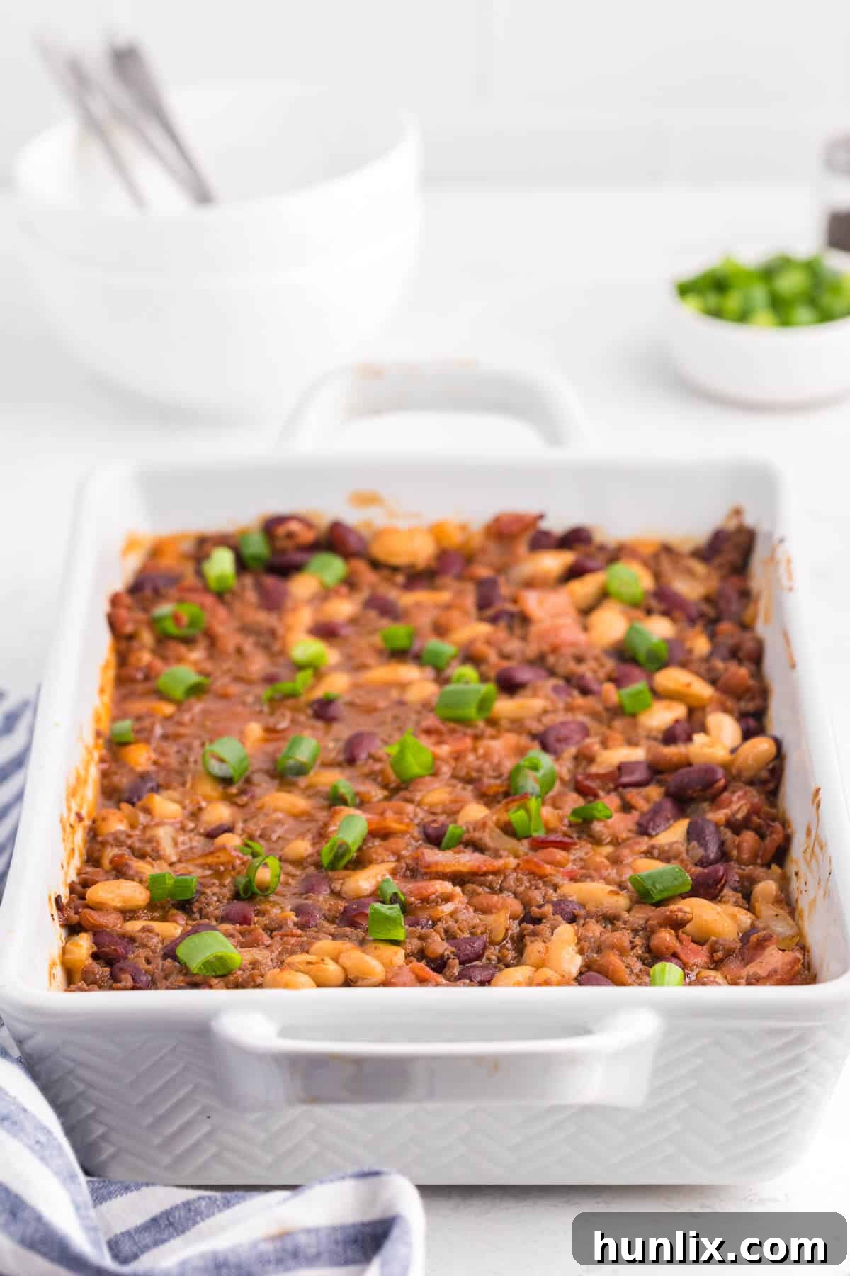 Baked bean casserole in a white casserole pan, ready to be served.