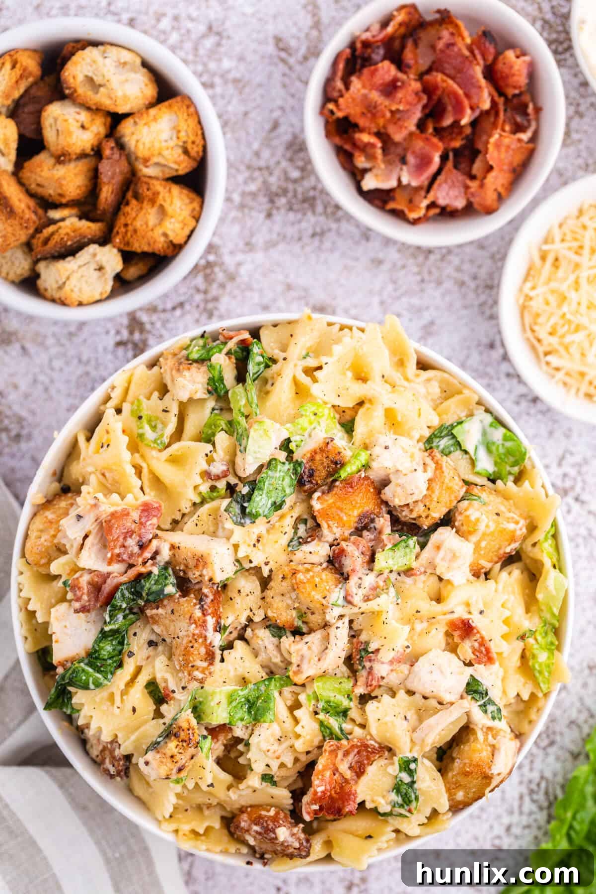 Signature Chicken Caesar Pasta 2 A large bowl of vibrant Chicken Caesar Pasta Salad, garnished with fresh herbs, ready to be served at a summer BBQ or poolside gathering.