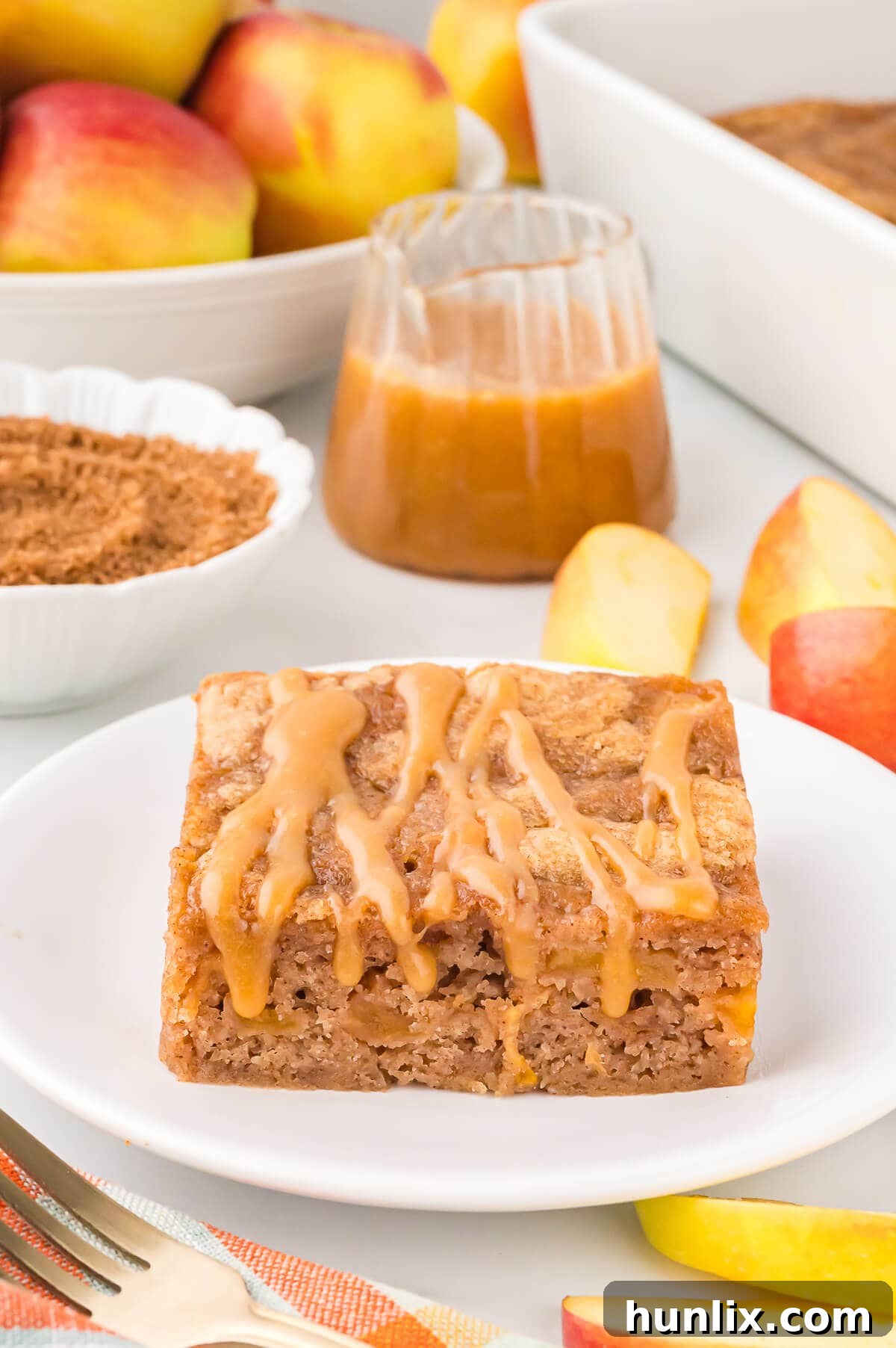 A delectable slice of apple cake with butterscotch sauce, elegantly plated and ready for enjoyment, showcasing its moist texture and golden crust.