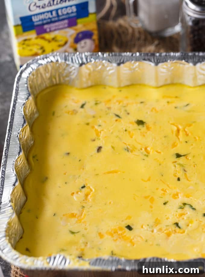 A transparent plastic baggie filled with freshly shredded cheddar cheese, neatly sealed and ready for transport to a camping trip. This demonstrates a practical food prep hack for camping.