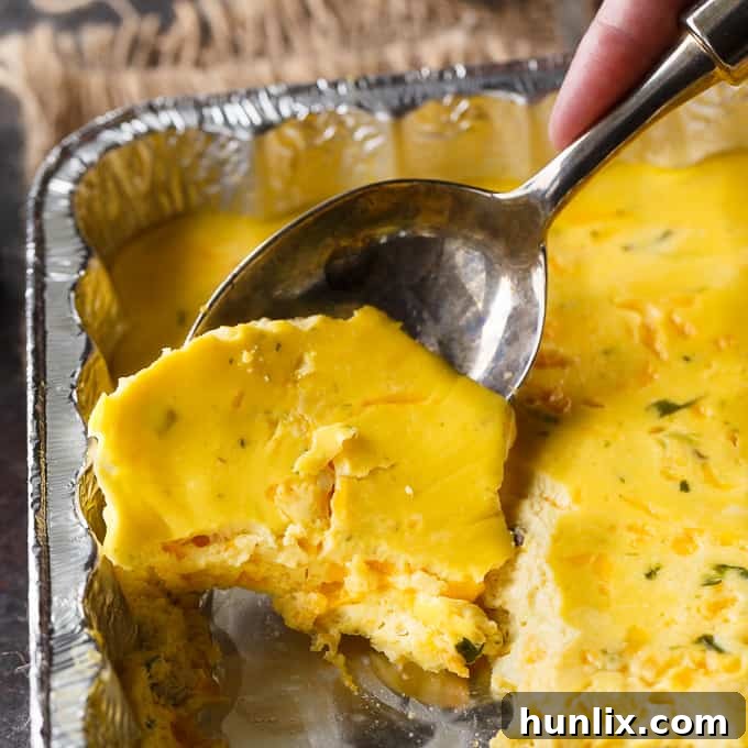 BBQ Eggs actively cooking in a disposable foil pan on a hot grill, tightly covered with aluminum foil to ensure even heat distribution and moisture retention, preparing a hearty camping breakfast.