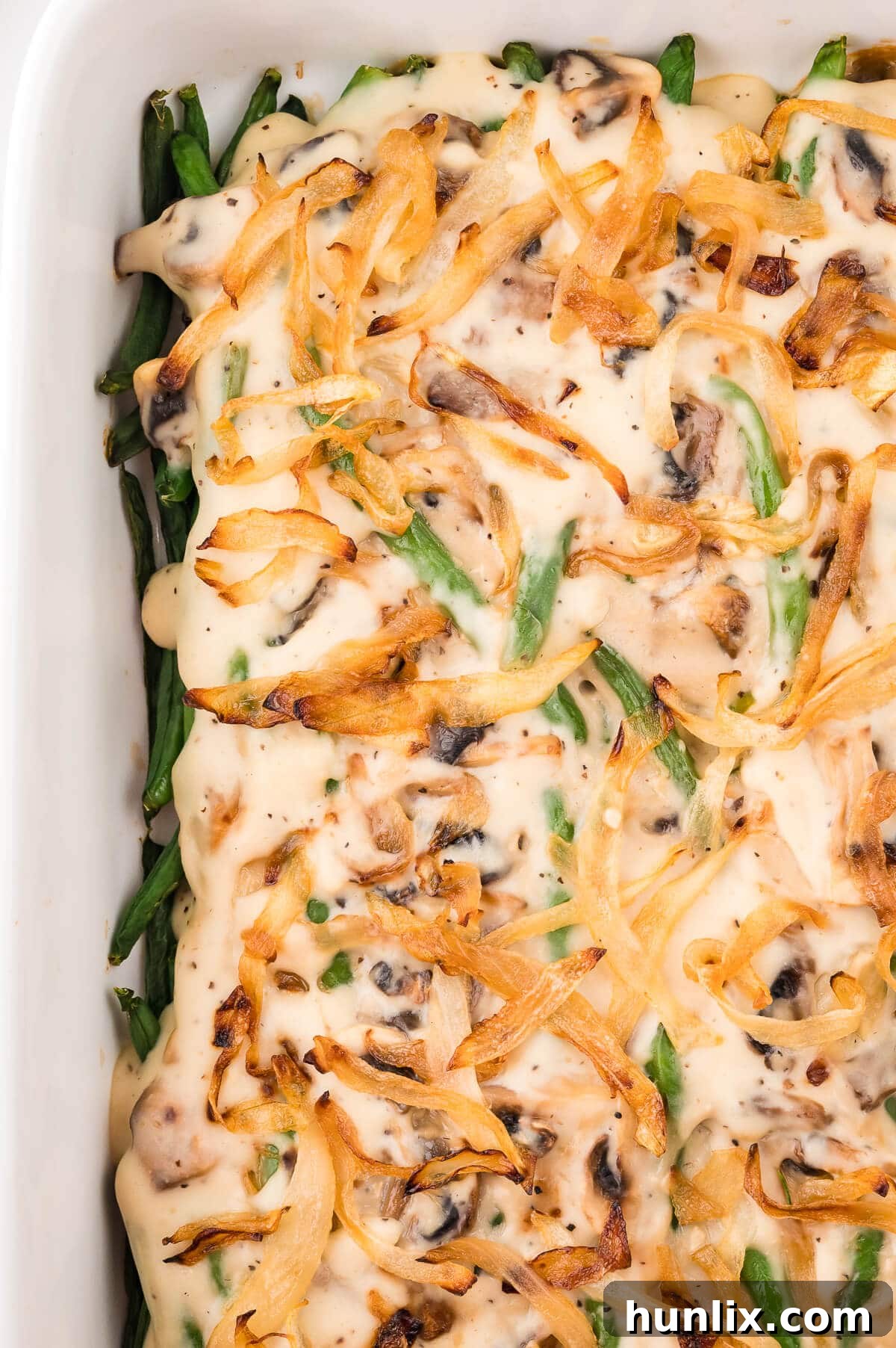 Homestyle Green Bean Bake 2 A bubbling, golden-brown homemade green bean casserole in a white baking dish, ready to be served.