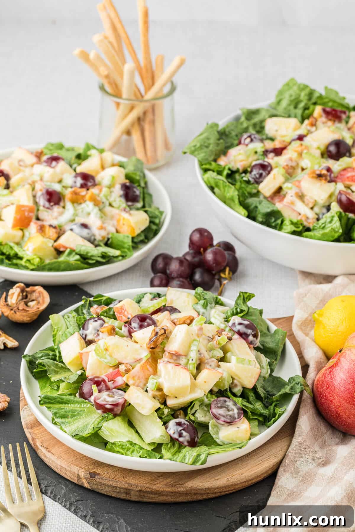 Multiple plates of Waldorf salad arranged artfully on a rustic table, inviting diners to enjoy this timeless classic, showcasing its fresh and vibrant appeal.
